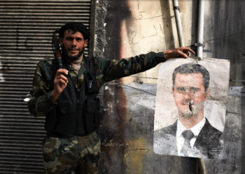 | An FSA fighter holds a bullet riddled poster of President Assad in Aleppo Syria March 30 2013 Sebastiano Tomada | SIPA | MR Online