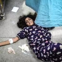 An injured Palestinian girl lies on the floor of Gaza’s Nasser Hospital, 22 January 2024. (Photo: Belal Khaled / Anadolu via Getty)