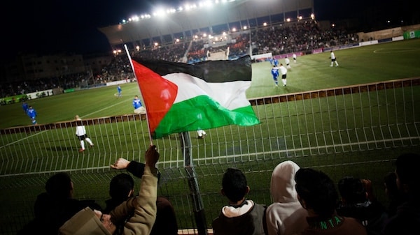 MR Online | Palestinian soccer supporters watch a match between the Palestinian team and Thailand in the West Bank town of Al Ram near Ramallah Bernat Armangue | AP | MR Online