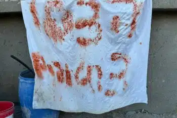 | A makeshift sign reading in Hebrew | MR Online'help, 3 hostages' using leftover food reportedly shown by Israeli hostages before being shot dead by Israeli soldiers, 17 December 2023 (AFP)