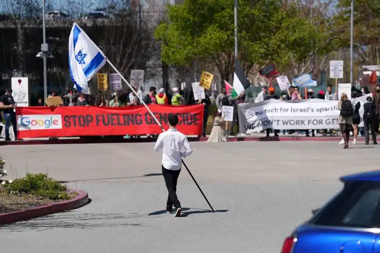 MR Online Part 5 | A counter protester holding an Israeli flag walks into the car park near a protest at Google Cloud offices in Sunnyvale California on April 16 2024 File ReutersNathan Frandino | MR Online