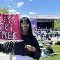 Avis Lee holds a banner for Let's Get Free, the Women and Trans Prisoner Defense Committee which helped with her fight for freedom and with which she now organizes to free others.