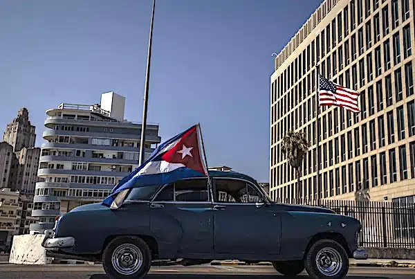 MR Online | A classic American car flying a Cuban flag drives past the US embassy during a rally calling for the end of the US blockade against Cuba Photo APRamon Espinosa | MR Online