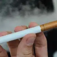 A person vaping with an e-cigarette.